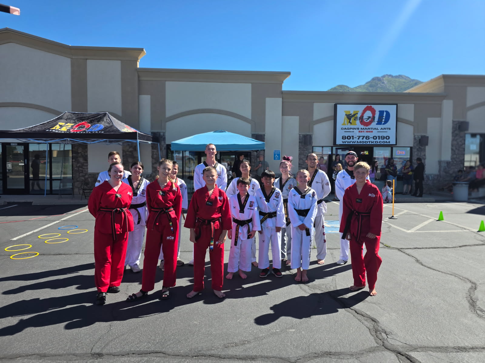 MOD Taekwondo South Ogden students and instructors posing together in front of the dojang entrance